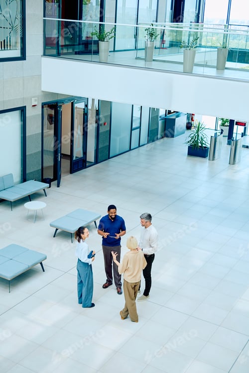 Preview: Business professionals meeting talking in a modern office lobby