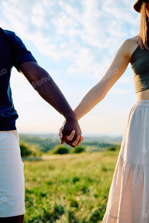 Preview: Multi-ethnic couple holding hands walking outdoors
