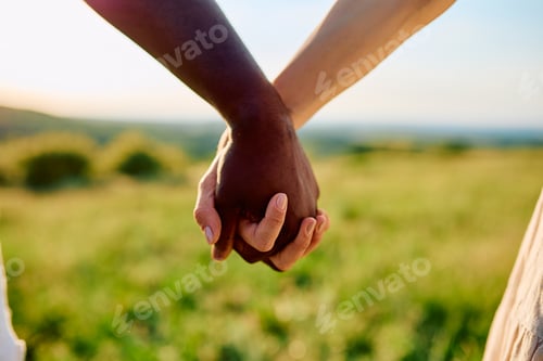 Preview: Diverse couple holding hands showing unity