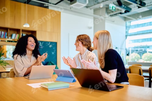 Preview: Diverse businesswomen clapping, celebrating teamwork success in office