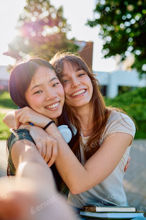 Preview: Young diverse women smiling, embracing together outdoors