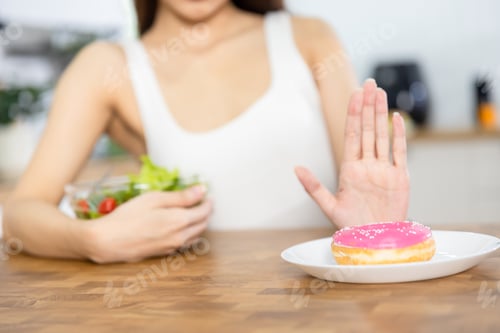 Preview: Woman rejecting unhealthy donut and choosing to eat fresh healthy salad
