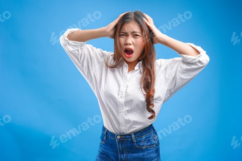 Preview: Stressful young Asian woman in a white shirt screaming and looking mad.