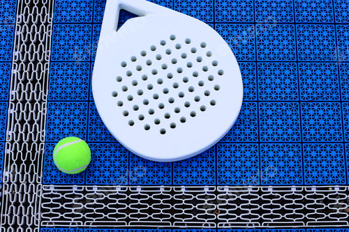 Preview: A padel racket and ball. on blue court