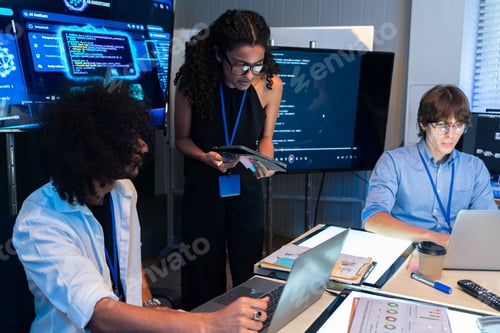 Three Focused Professionals Collaborating in a Modern Tech Office