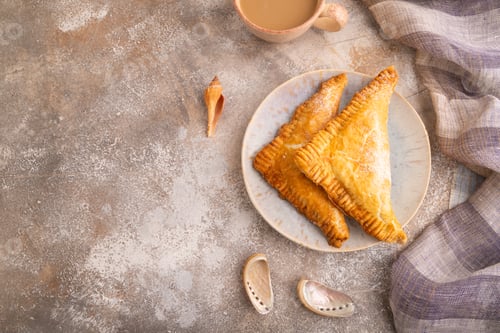Preview: Triangles Pie, Puff Pastry, Samsa with cherry jam on brown concrete, top view, flat lay, copy space