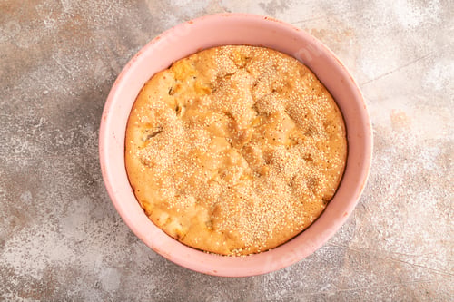 Preview: Apple Charlotte cake in baking dish on brown concrete, top view, flat lay, close up
