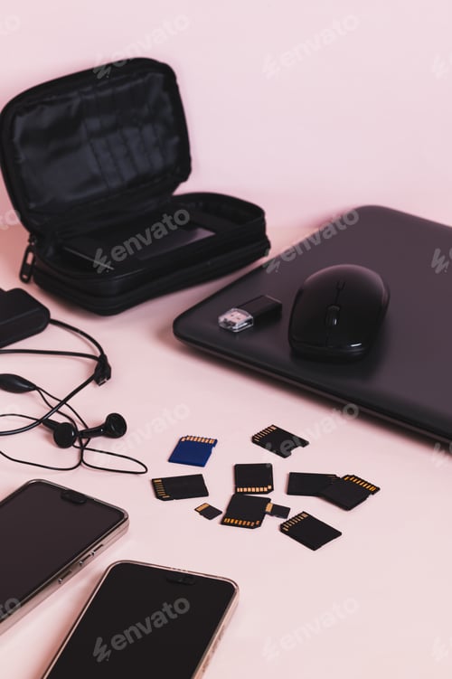 Preview: Flash drives, smartphones, a laptop, headphones, and a hard drive on the table vertical view