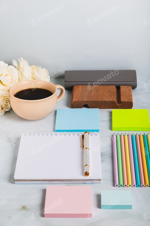 Preview: A notebook, pen, cup of coffee and stationery on a desk vertical view
