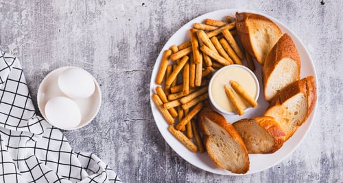 Preview: Hollandaise sauce with breadsticks and toast on a plate on the table top view web banner