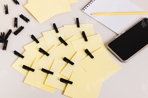 Preview: A pile of identical notepads, a smartphone, a notebook, and a pencil on the table