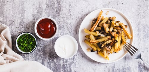 Preview: Crispy French fries served with mushrooms on a plate on the table top view web banner