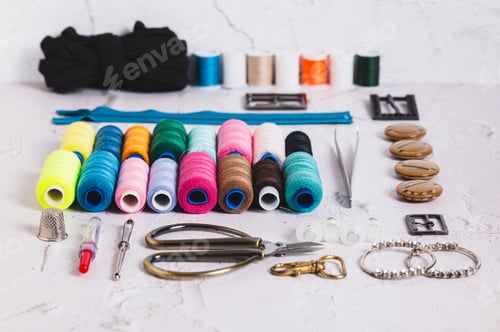 Preview: A set of spools of multi-colored threads and sewing supplies on a table