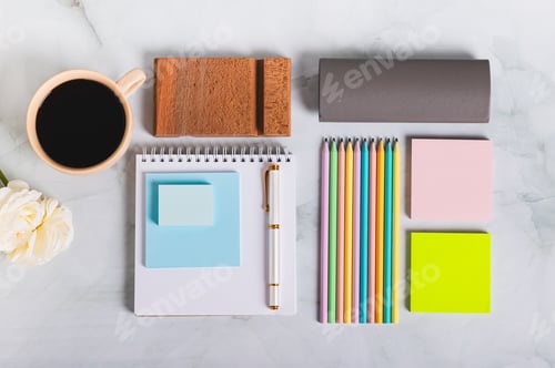 Preview: A notebook, pen, cup of coffee and stationery on a desk top view