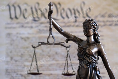 Preview: Lady Justice statue with scales on background of US Constitution page. Lawsuit and punishment in US