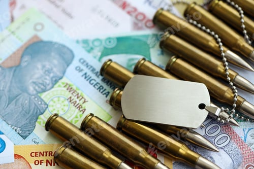 Preview: Nigerian naira currency money bills and rifle bullets with dogtag. The concept of warfare and army s