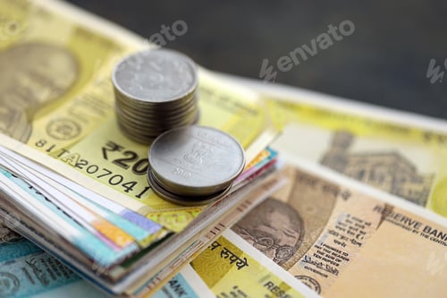 Preview: Indian rupee money bills and paisa coins pile on table. India coins on banknotes of INR currency