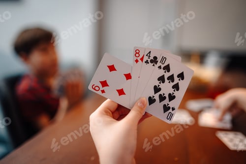 Preview: Holding playing cards during family game night