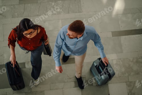 Preview: Business couple traveling pulling luggage in airport