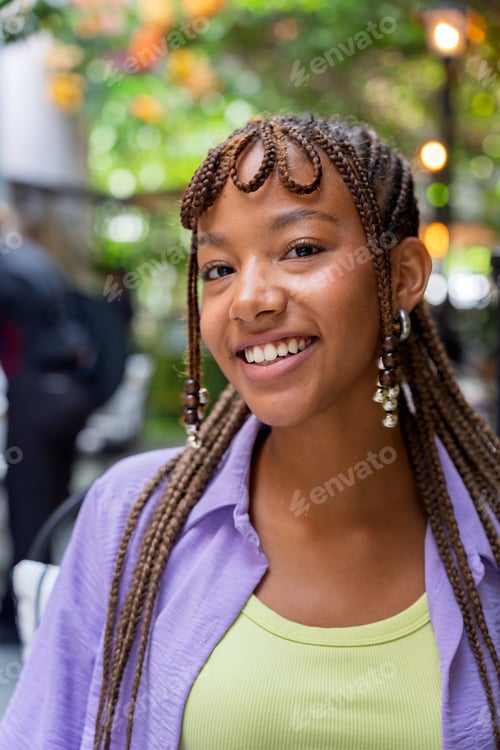 Preview: Young woman smiling with unique braided hairstyle outdoors