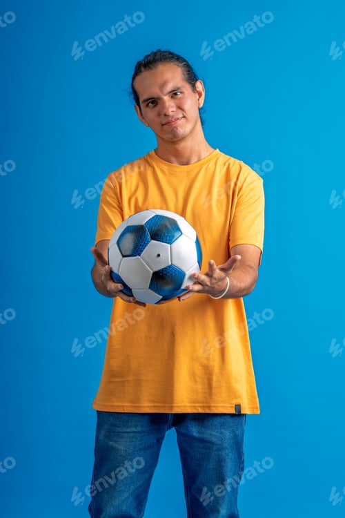 Preview: Young man holding soccer ball smiling at camera