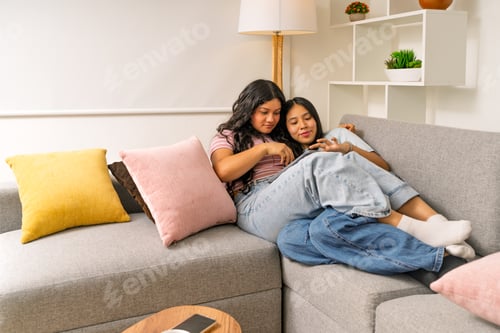 Preview: Young women friends sharing content on tablet at home