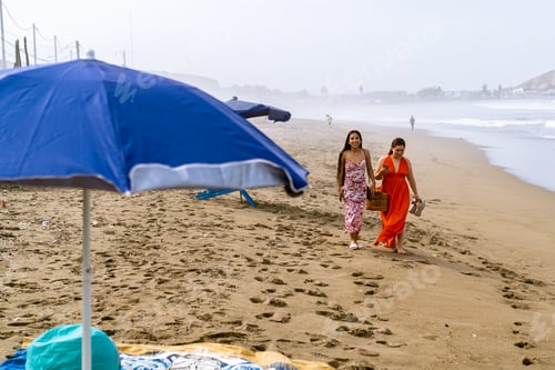 Preview: Young women enjoying leisure walk on a sandy beach