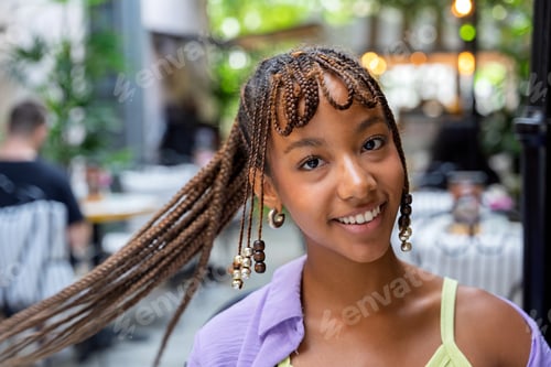 Preview: Young woman smiling with braided hair urban
