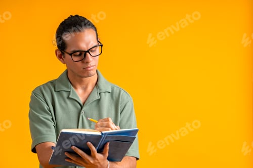 Preview: Young man writing in notebook, planning ideas