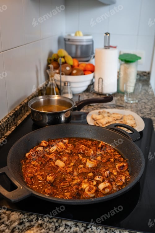 Preview: Cooking seafood paella with squid in a kitchen pan