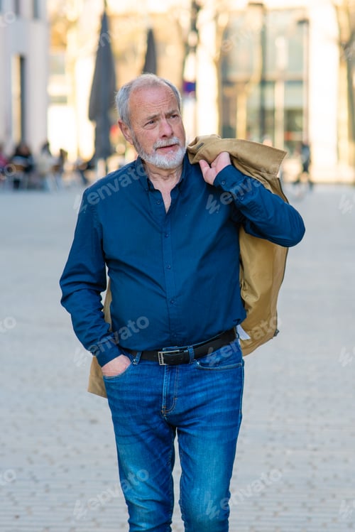 Preview: Senior man walking city street with jacket on shoulder