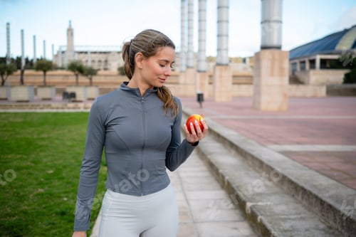 Preview: Woman enjoying healthy apple after fitness workout in Barcelona