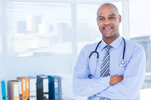 Preview: Stethoscope is resting over light blue shirt and striped tie in office near blinds, copy space