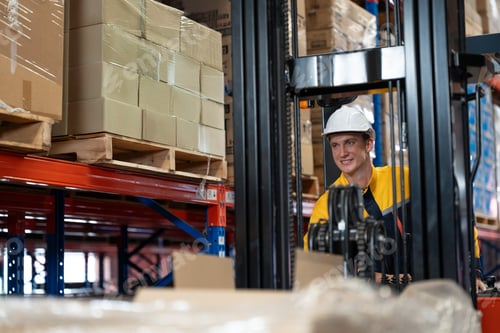 Preview: Smiling forklift driver moves goods to warehouse shelves