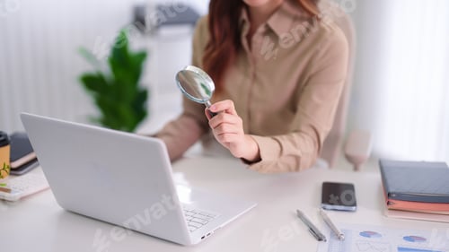 Preview: Businesswoman Holding Magnifying Glass Over Laptop Computer Researching Data Analysis Financial Repo