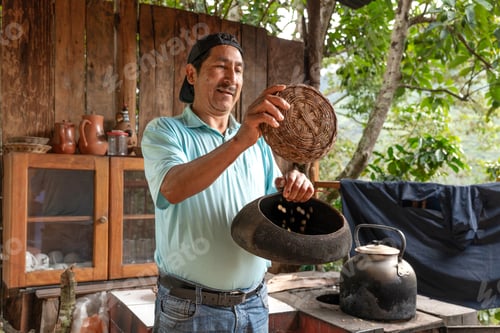 Preview: A Latin American farmer showing traditional coffee roasting process with beans