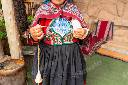 Preview: Close-up of Andean craftswoman spinning wool with drop spindle in rural Peru