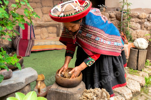 Preview: Andean woman working with alpaca wool outside rural home