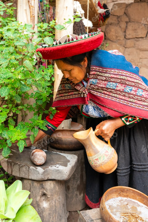 Preview: Indigenous Andean woman pouring water in rustic village courtyard