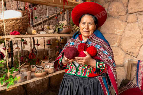 Preview: Andean woman wearing traditional clothing and holding alpaca wool yarn in a textile workshop