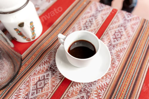 Preview: Cup of homemade coffee on a rustic table with traditional Latin American textile