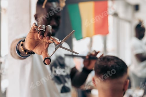 Preview: Close up of barber holding scissors and comb during men haircut in barbershop