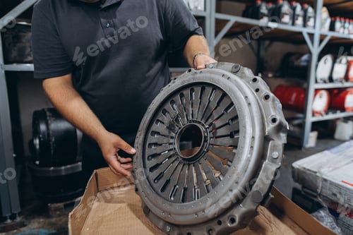 Preview: Mechanic holding new clutch assembly for car repair