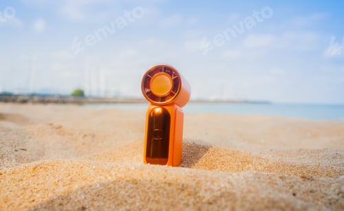 Preview: Portable handy fan on the beach and the background is the sea and the sky in summer.