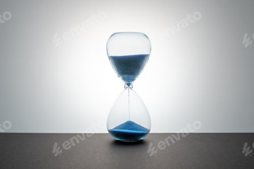 Preview: A glass hourglass with flowing blue sand sits on a dark surface against a bright, backlit gradient b