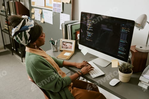 Preview: Black Woman Software Developer Coding at Desk in Home Office