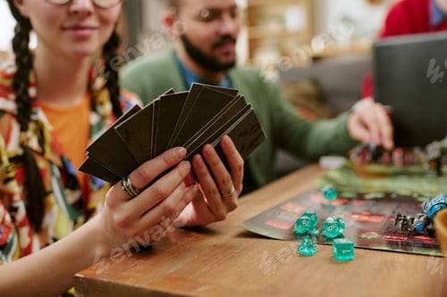 Preview: Adult Woman Holding Game Cards during Tabletop Gaming Session