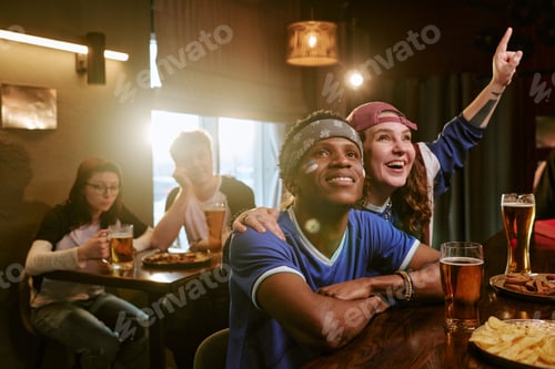 Preview: Multiethnic Friends Watching Sports in Bar and Celebrating Win