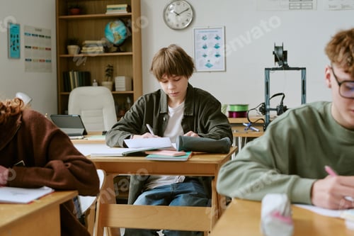 Preview: Teenage Boy Taking Written Exam in Classroom for School Assessment