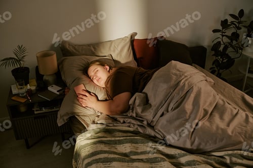 Preview: Plus Size Woman Sleeping While Holding Smartphone in Bed at Night